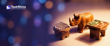 A small wooden rhino stands between two small pedestals, looking from one to the other: on one a clear glass block divided into a grid of tiny cells, on the other a tidy board of coloured tiles.