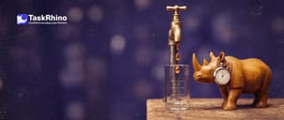 A small wooden rhino times with a small stopwatch a brass tap dripping glowing drops into a measuring glass marked only with lines.