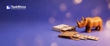 A small wooden rhino pulls a brass lever on a small machine; a paper card goes in from a card box and a tiny wooden folder opens with three small tile boards sliding out.