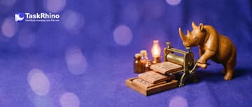 A small wooden rhino turns the crank of a tiny brass printing press that lays out three identical small tile boards in a neat stack.