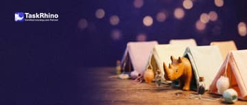 A small wooden rhino peeks into one of a row of seven tiny canvas tents in different soft colours pitched on a wooden table.