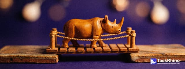 A small wooden rhino walks across a small wooden bridge linking two tile boards.