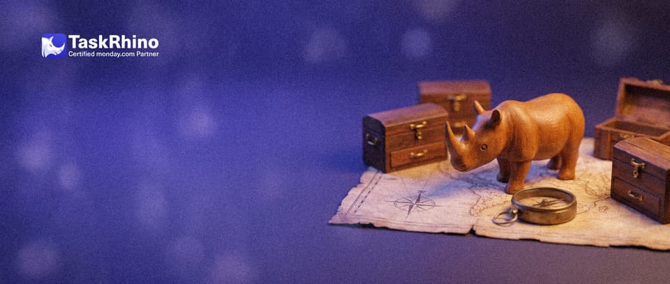 A small wooden rhino stands on an unfolded paper map with several small tool chests placed on it like towns, a brass compass at its feet.