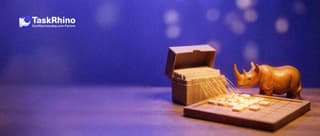 A small wooden rhino watches golden threads pour glowing tiles from a small index card box into a fresh empty tile board.