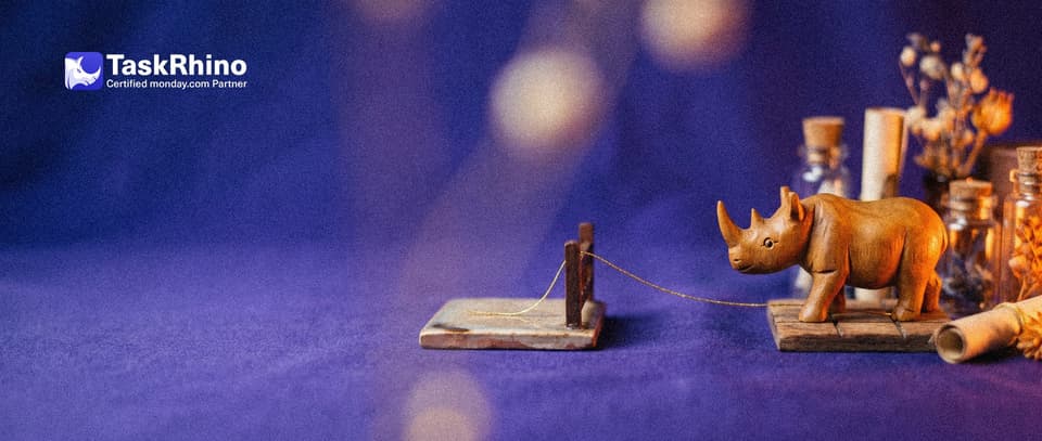 A small wooden rhino looks at a golden thread stretched from one tile board toward another that stops short at a gap with a small wooden barrier.