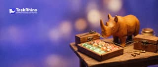 A small wooden rhino plugs a brass connector on a golden thread into a tidy board of coloured tiles; other threads lead to small different tool boxes.