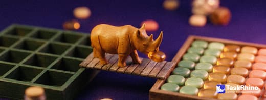 A small wooden rhino carries items from a green wooden grid of small square cubbies into a tidy board of coloured tiles, nothing dropped on the way.