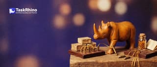 A small wooden rhino holds a loose brass plug: the original tile board is plugged into small boxes by golden threads, its copy beside it has its plugs dangling.