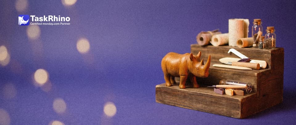 A small wooden rhino stands on the middle of three wooden steps of rising height, each step holding a bigger set of small paper form tools.