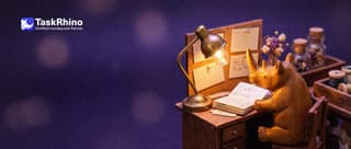 A small wooden rhino sits alone at a tiny wooden desk under a small glowing desk lamp, with one neat notebook and a few index cards pinned up.