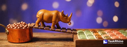 A small wooden rhino carries items from an orange copper pot of small round beads into a tidy board of coloured tiles, nothing dropped on the way.
