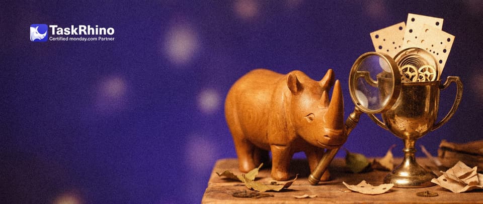 A small wooden rhino inspects a gleaming gold trophy cup filled with tiny gears and punched paper cards through a brass magnifying glass.
