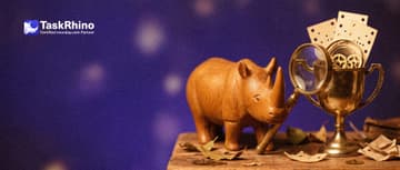 A small wooden rhino inspects a gleaming gold trophy cup filled with tiny gears and punched paper cards through a brass magnifying glass.