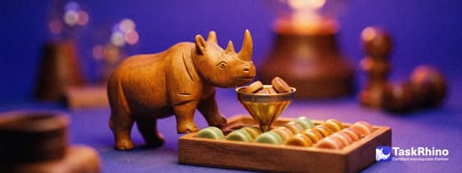 A small wooden rhino drops wooden tokens into a brass funnel that feeds them neatly into a board of coloured tiles.