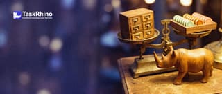A small wooden rhino points to the heavier side of a balance scale: an old dusty card cabinet on one pan and a tidy board of coloured tiles on the other.