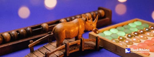 A small wooden rhino carries items from a long wooden timeline rail with sliding beads into a tidy board of coloured tiles, nothing dropped on the way.