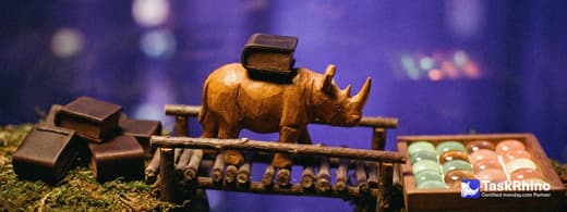A small wooden rhino carries items from a stack of plain leather-bound blocks into a tidy board of coloured tiles, nothing dropped on the way.
