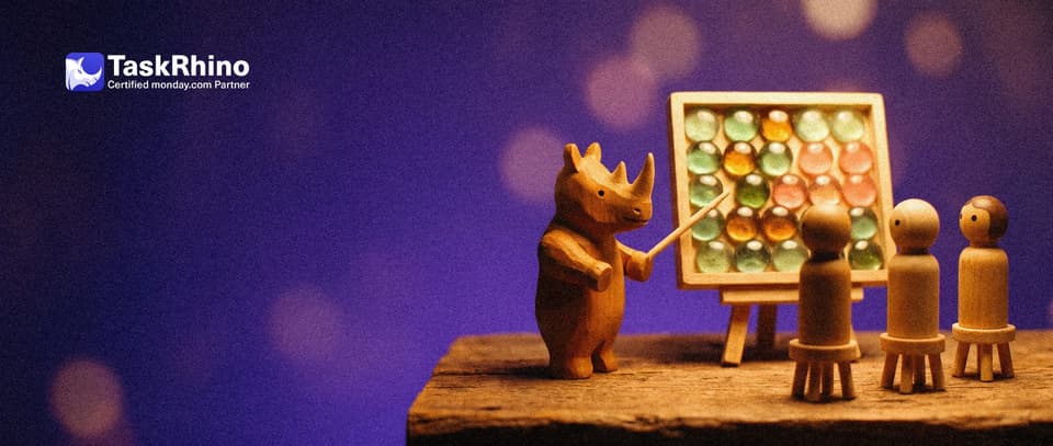 A small wooden rhino points with a little wooden pointer at a tidy board of coloured tiles on an easel while three wooden peg students watch.