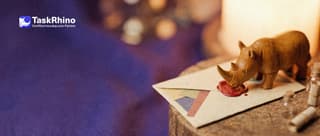 A small wooden rhino seals a beautifully decorated envelope with coloured paper inlays and a red wax seal.