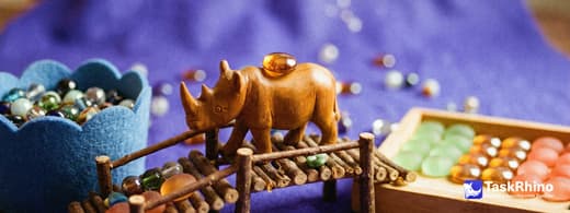 A small wooden rhino carries items from a small cloud-shaped blue felt basket of beads into a tidy board of coloured tiles, nothing dropped on the way.
