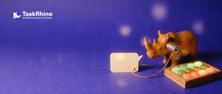 A small wooden rhino holds a tin-can telephone to its ear; the golden string runs from a small paper speech bubble to a tidy board of coloured tiles.