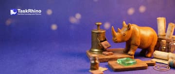 A small wooden rhino catches a new tile dropping from a little brass dispenser onto a second board as a tile on the first board glows green.