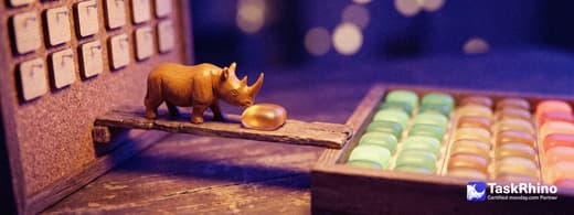 A small wooden rhino carries items from a small cork board with wooden tiles pinned in columns into a tidy board of coloured tiles, nothing dropped on the way.