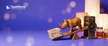 A small wooden rhino stands at the middle of a wooden seesaw: a light open wooden crate on one end, a heavy brass machine on the other.